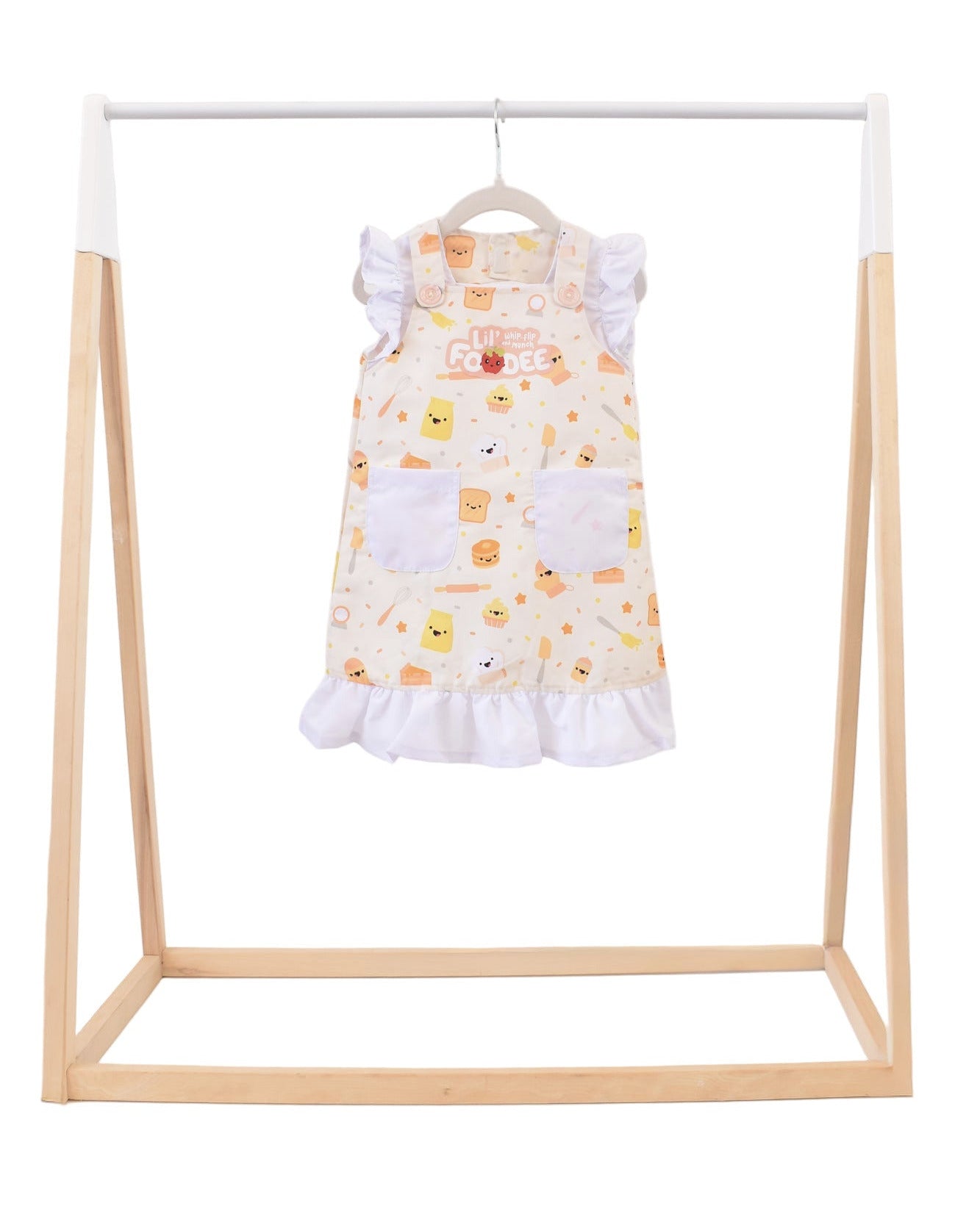 Lil' Foodee Lil Baker frill apron featuring pastel baking icons and ruffled edges.