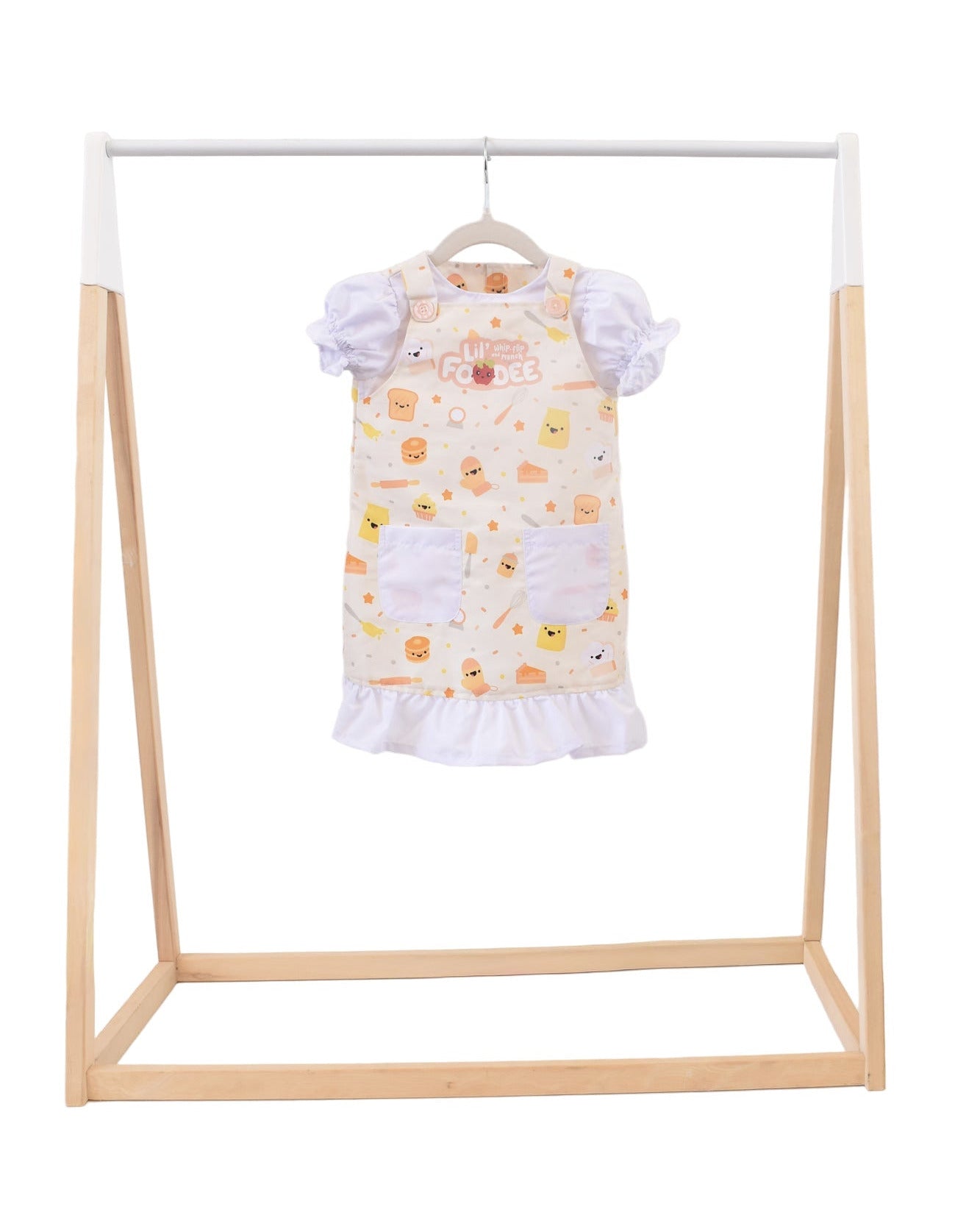 Lil' Foodee Lil Baker puff-sleeve apron in pastel baking print with cupcakes, whisks and sprinkles.