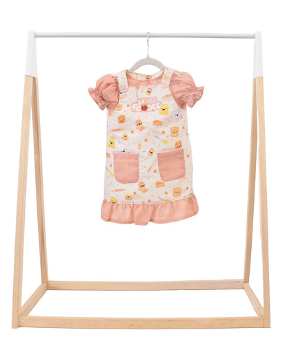 Lil' Foodee Lil Baker puff-sleeve apron in pastel baking print with cupcakes, whisks and sprinkles.